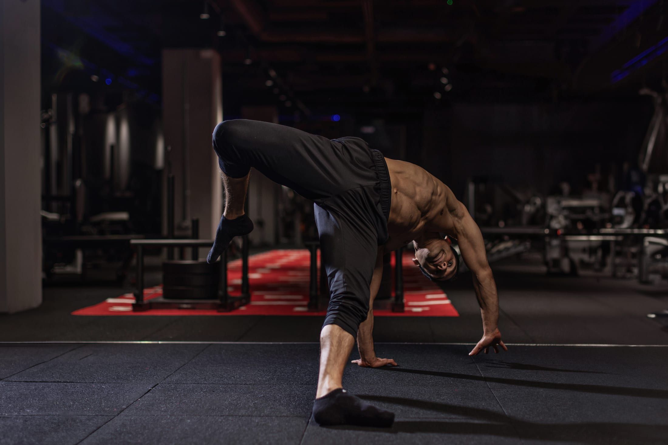 Gurinder Sandhu mid animal-flow movement on the gym floor at UNTIL Soho