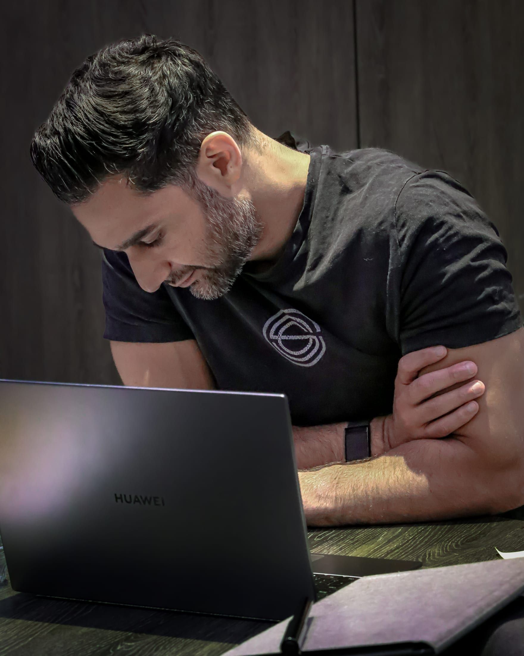Gurinder Sandhu studying at a laptop, head down over his notes